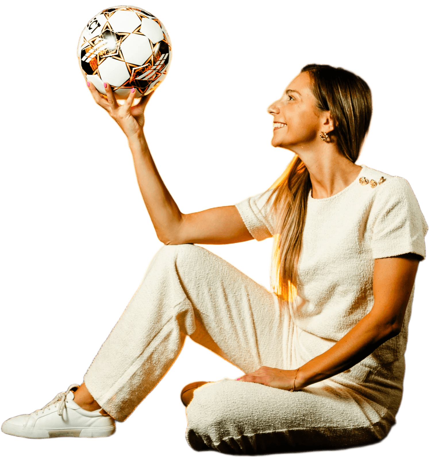 Filipa Marques sentada, a segurar uma bola de futebol